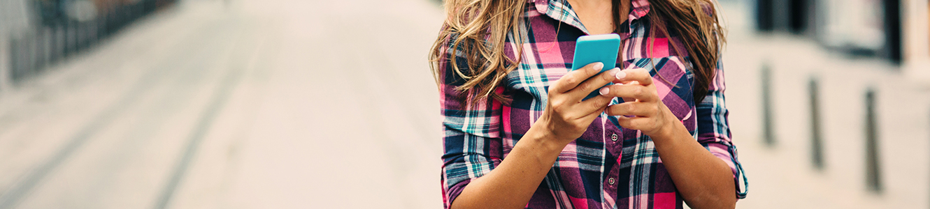 Lady with smartphone walking down street